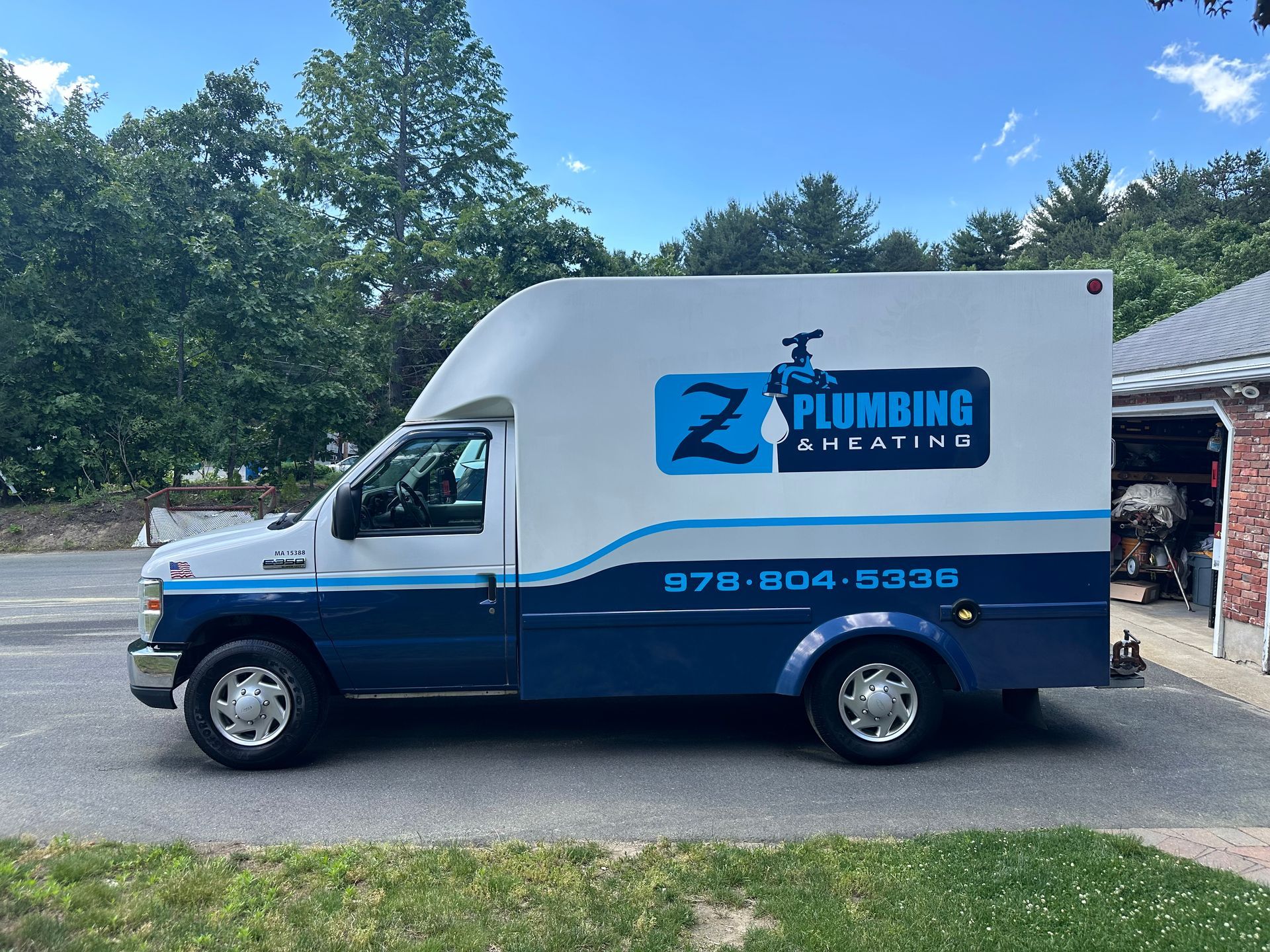 A plumbing truck is parked in front of a house