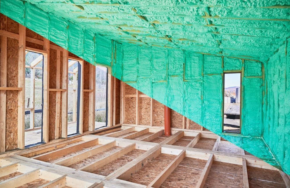 Half-finished room construction, with wooden frame and green spray foam insulation.