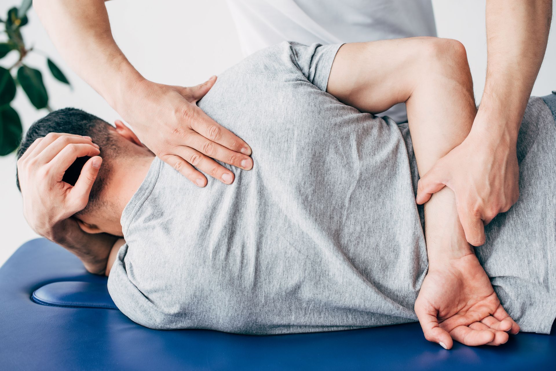 A chiropractor massaging a man's back, lying on a massage table for chiropractic treatment.