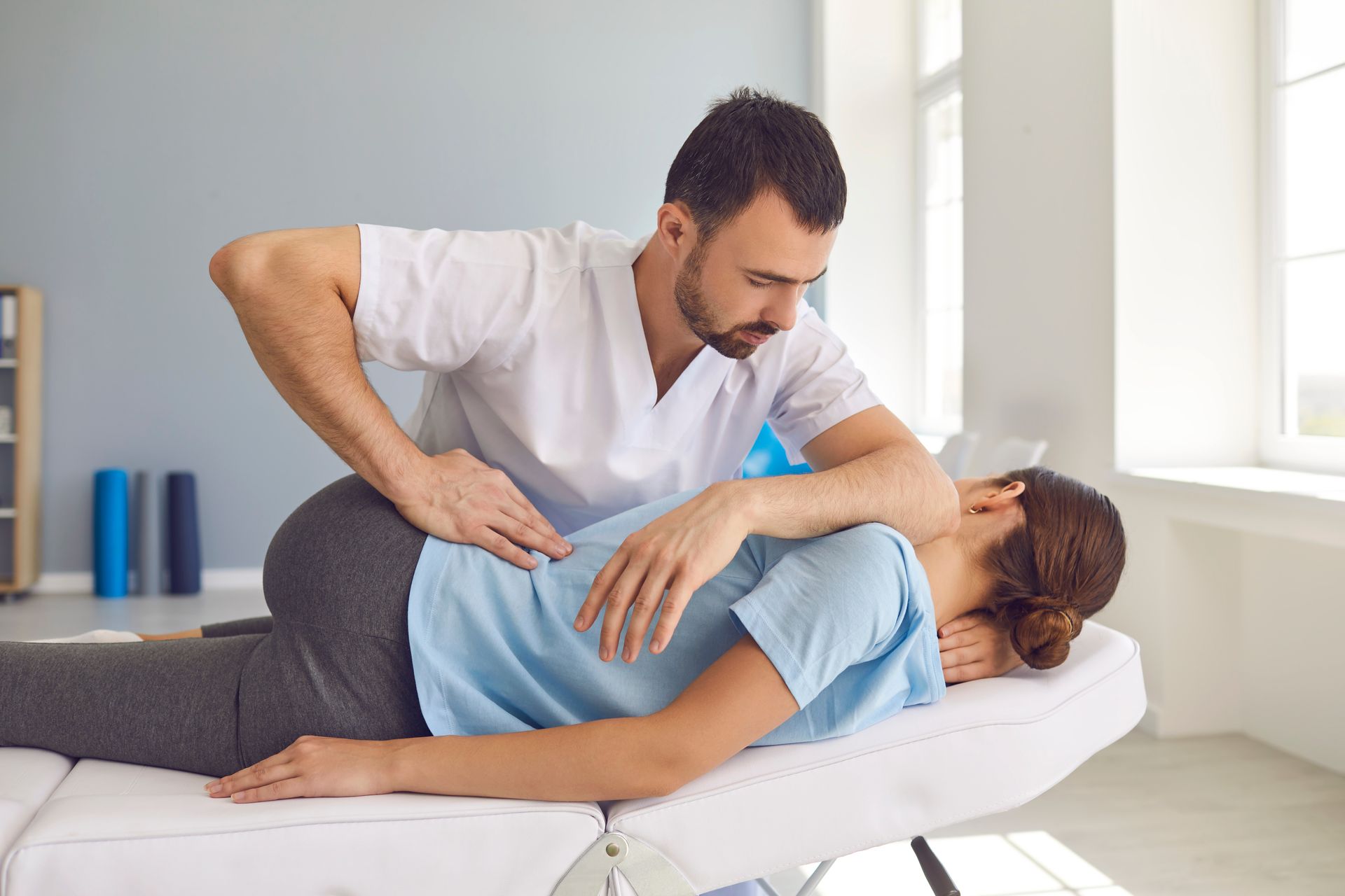Therapist applying pressure to a patient’s back during a treatment session.
