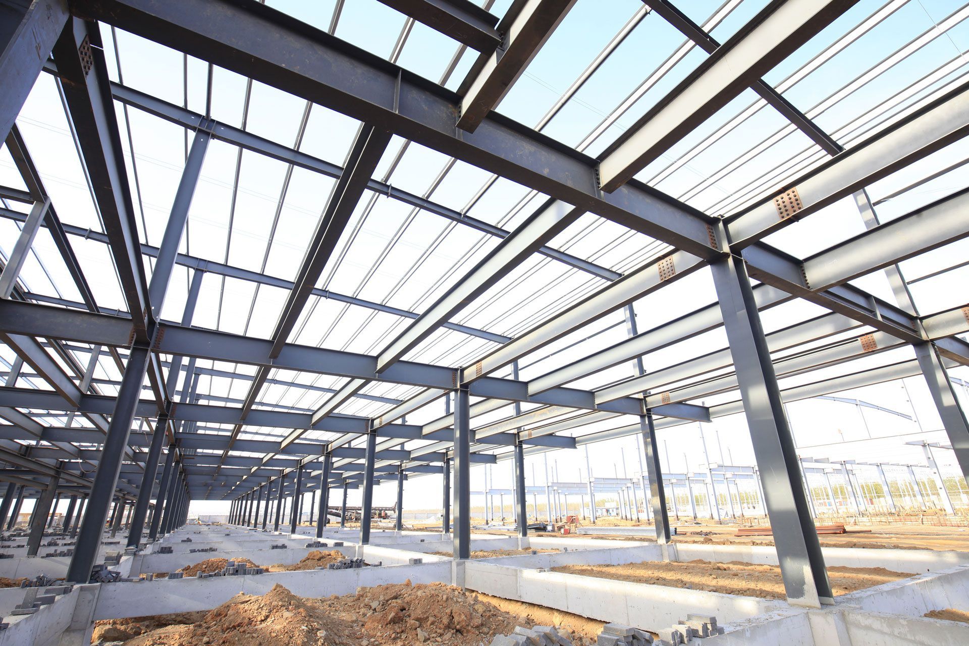 Steel frame of a building under construction with sunlight through the roof beams
