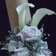 White calla lilies and pale lavender roses arranged in a bouquet with silver accents