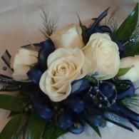 White roses with dark blue accents in a compact floral bouquet