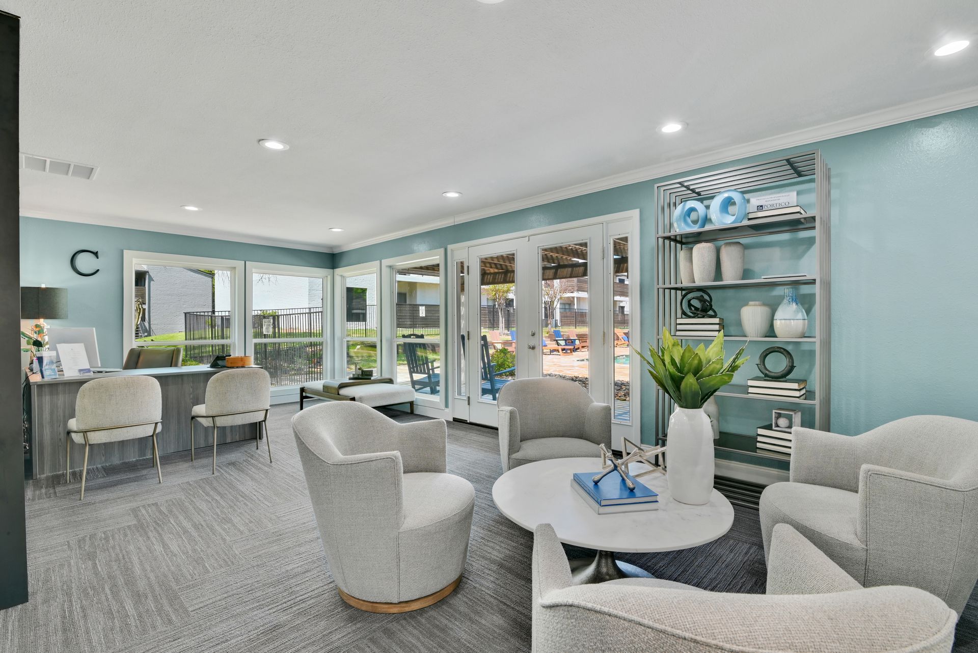 Bright waiting area with light blue walls, white chairs, and a round coffee table.
