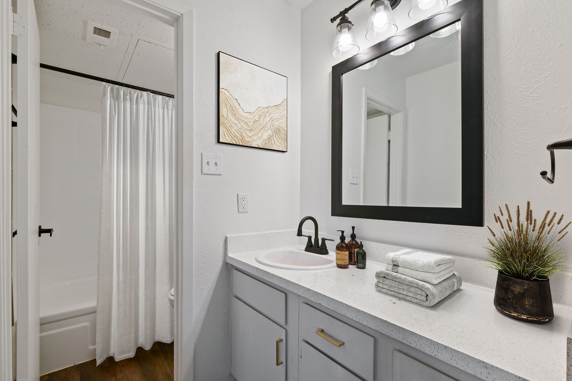 Bathroom with white countertop, black accents, and decorative elements.