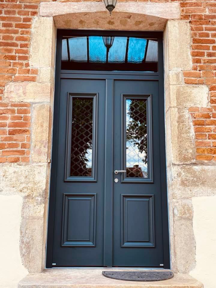 Porte avec teinte extérieure gris anthracite et teinte intérieure blanc installé par TRIHOME Menuiseries à Clux-Villeneuve