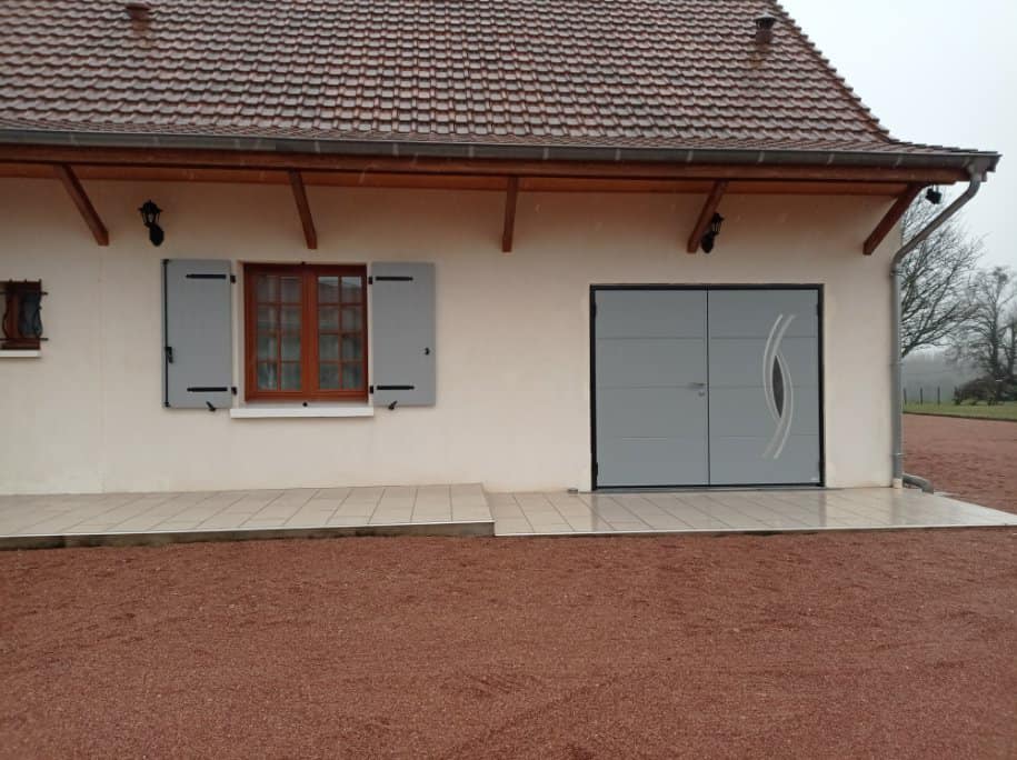Bel ensemble porte de garage et volets battants installé par TRIHOME Menuiseries à Saint-Vincent-en-Bresse, en Bresse Louhannaise