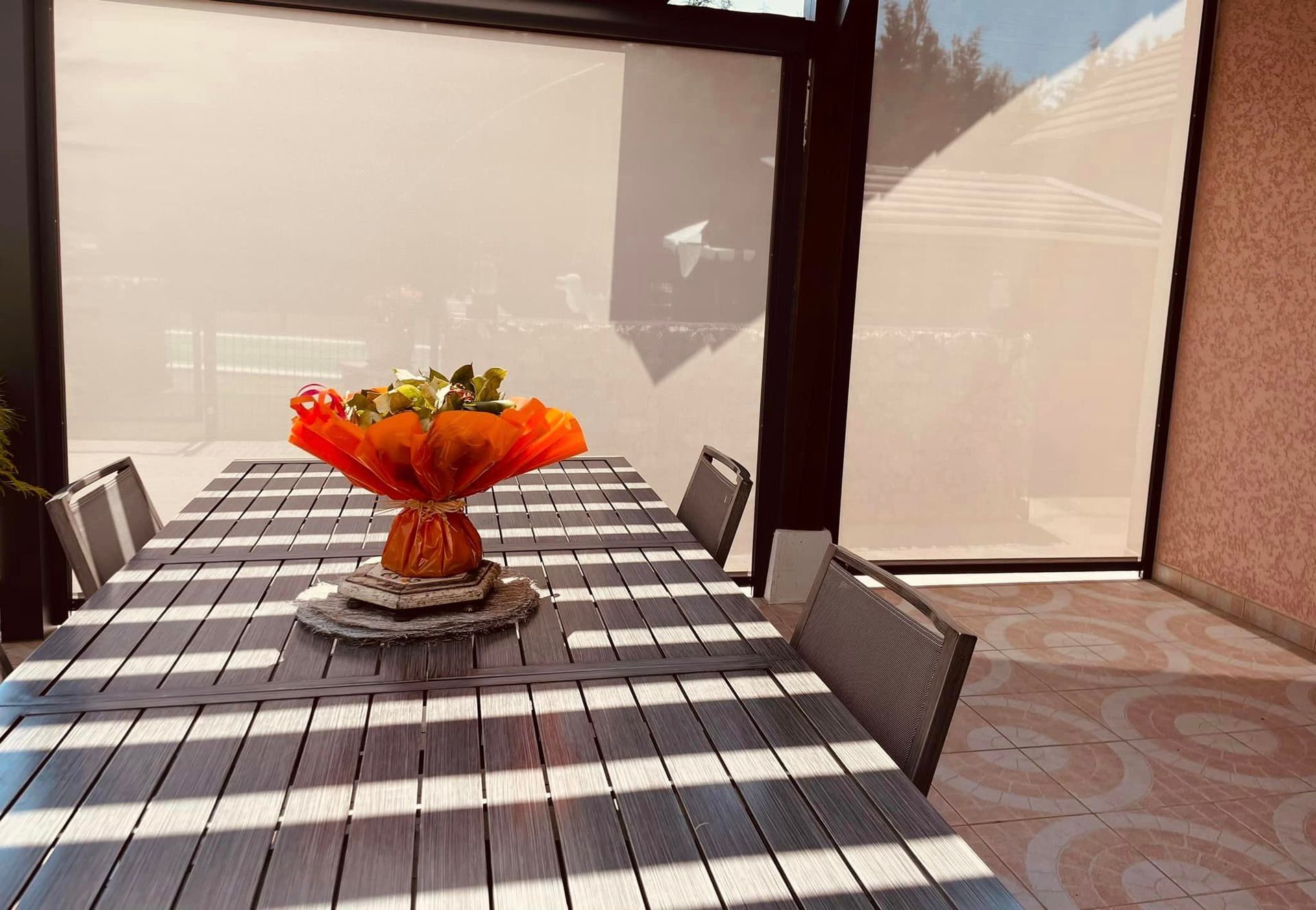 Pergola avec habillages alu laqués des poutres adjacentes installé par TRIHOME Menuiseries à Saint-Usuge