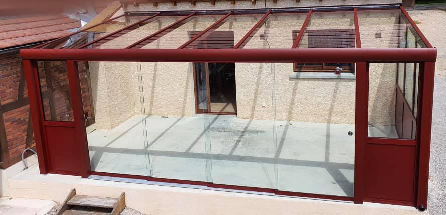 Pergola à toiture vitrée avec coulissants en verre trempé par TRIHOME Menuiseries à Saint Germain du Bois en Bresse Louhannaise