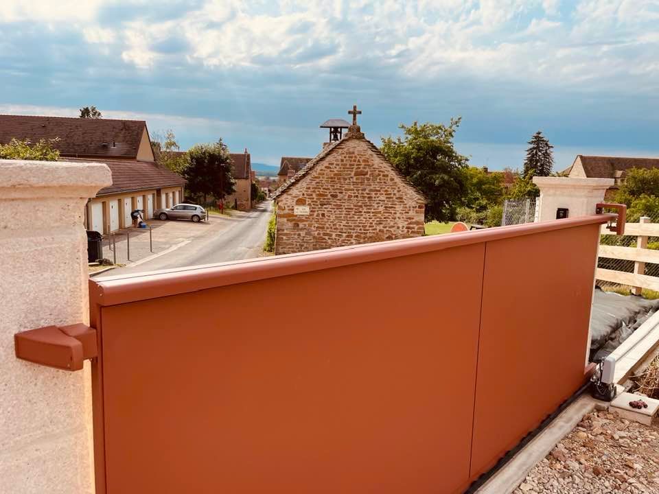 Portail avec finition intérieure teinte Terracota installé par TRIHOME Menuiseries à Nanton
