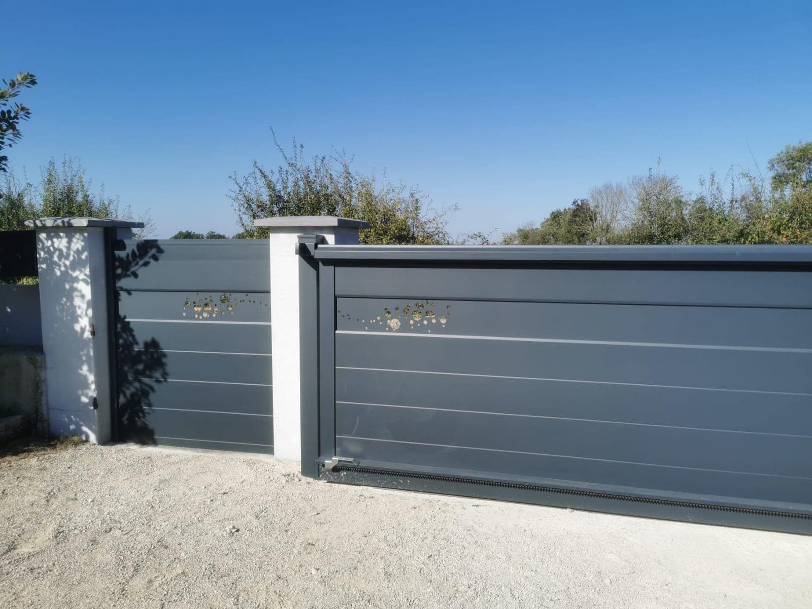 Portail coulissant sur rail motorisé installé à Sens-sur-Seille par TRIHOME Menuiseries, en Bresse bourguignonne