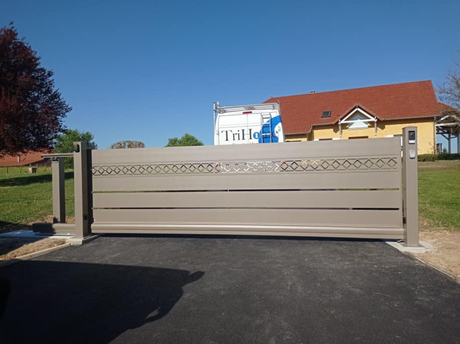 Portail coulissant aux motifs ajourés installé à Frontenaud par TRIHOME Menuiseries, en Bresse bourguignonne