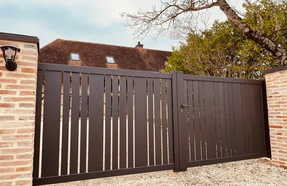 Portail sur mesure avec barreaux de diverses largeurs installé à Villegaudin par TRIHOME Menuiseries, en Bresse bourguignonne