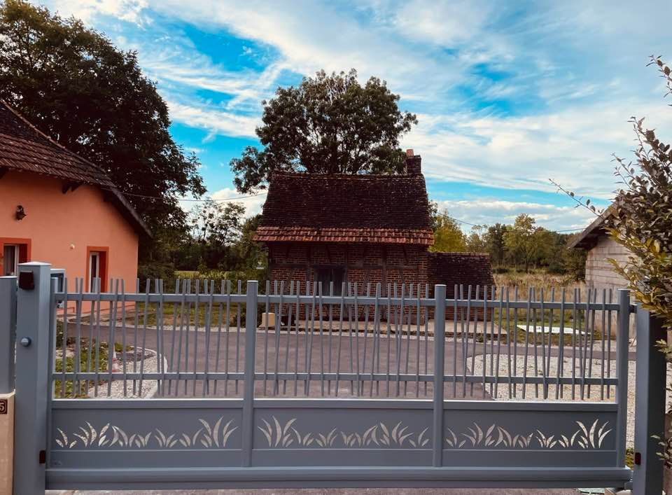 Portail motif sur mesure gamme Arcana installé à Sens-sur-Seille par TRIHOME Menuiseries, en Bresse bourguignonne