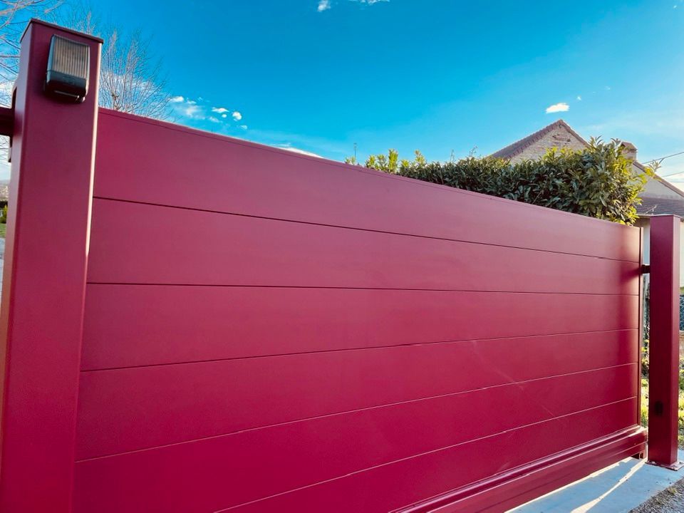 Portail teinte rouge basque RAL 3004 installé par TRIHOME Menuiseries à Cousance