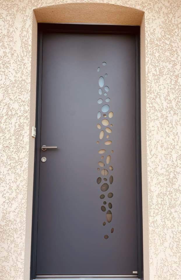 Porte d’entrée avec hublots galets installée à Mervans par TRIHOME Menuiseries, en Bresse bourguignonne