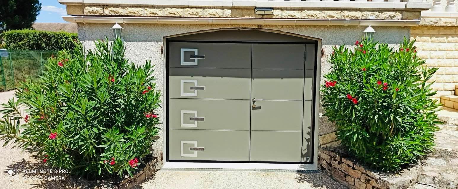 Porte de garage avec inserts en ardoise sur mesure installée à Saint-Marcel par TRIHOME Menuiseries, en Bresse bourguignonne