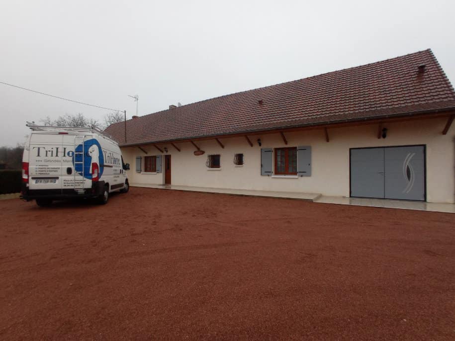 Porte de garage deux battants et volets battants installés par TRIHOME Menuiseries à Saint-Vincent-en-Bresse.