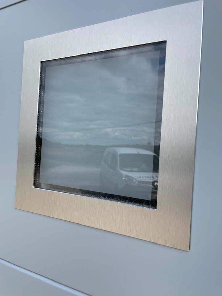 Porte de garage lumineuse grâce aux trois hublots installée par TRIHOME Menuiseries à Saint-Germain-du-Bois.