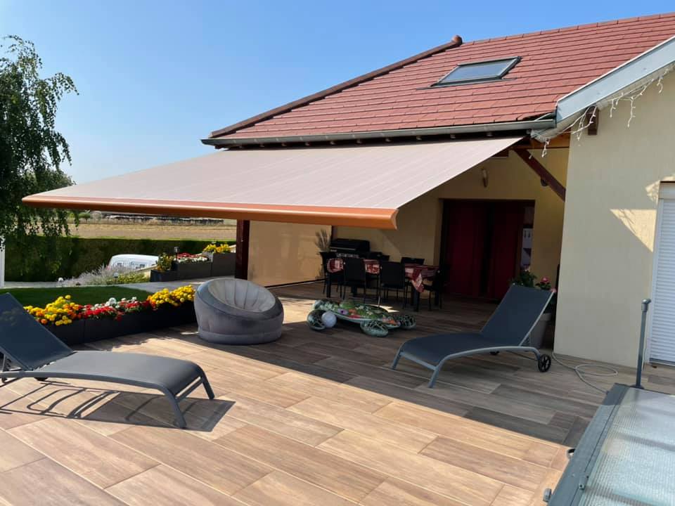 Stores banne qui protègent et illuminent la terrasse installés par TRIHOME Menuiseries à Fretterans en Bresse Louhannaise