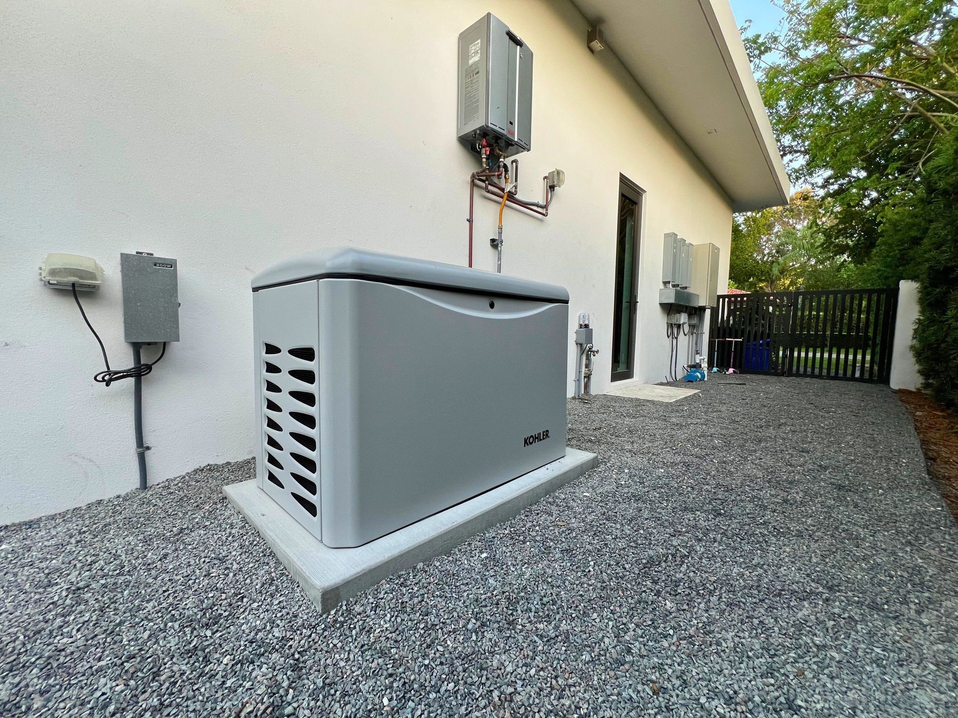 A generator is sitting outside of a white building.