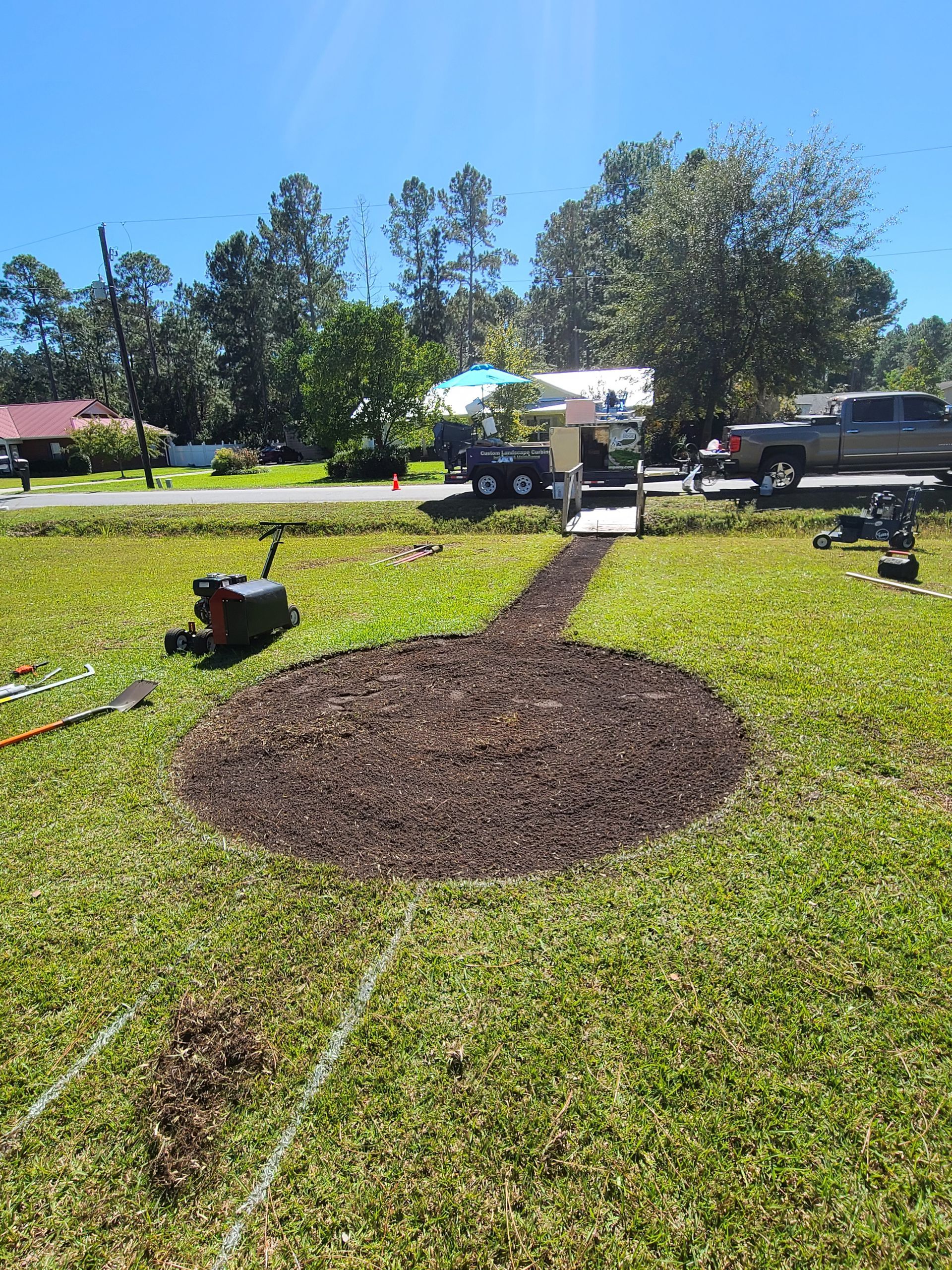A circle of dirt in the middle of a lush green field.