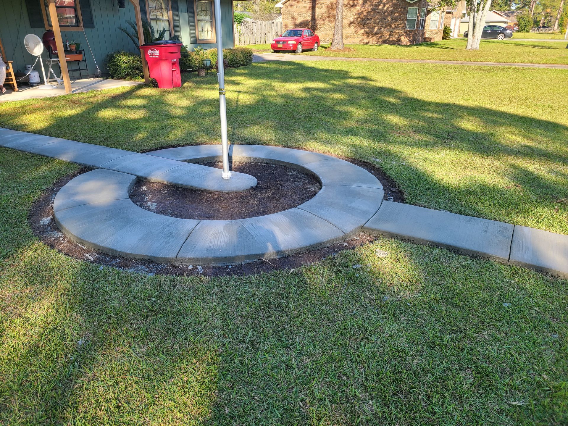 A concrete walkway in the middle of a lush green lawn.