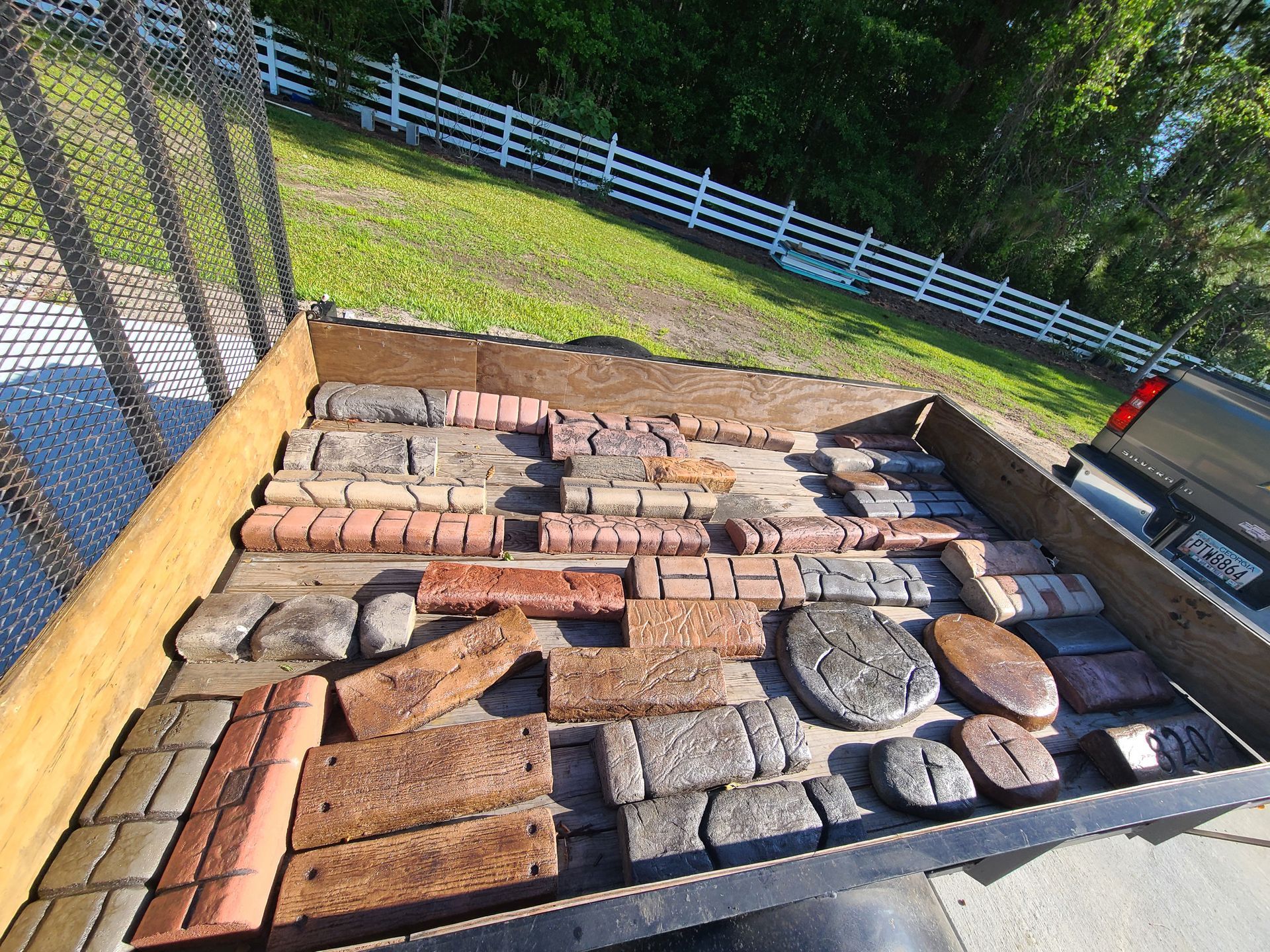 A box filled with bricks and rocks is in the back of a truck.