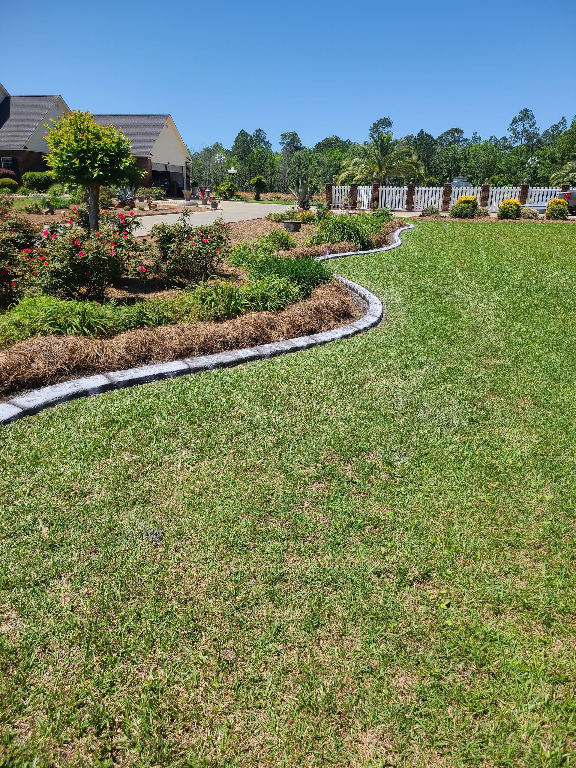 A large lush green lawn with a house in the background.