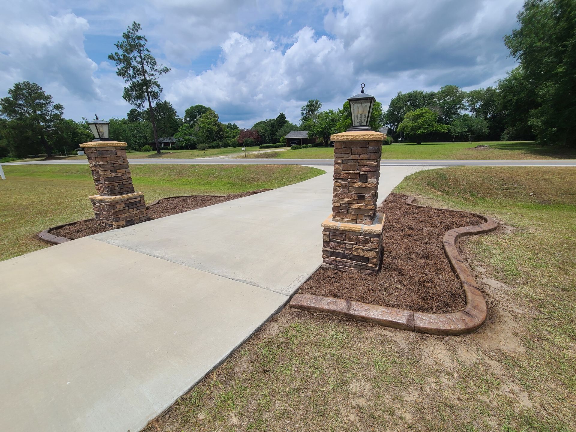 There are two stone pillars on the side of the road.