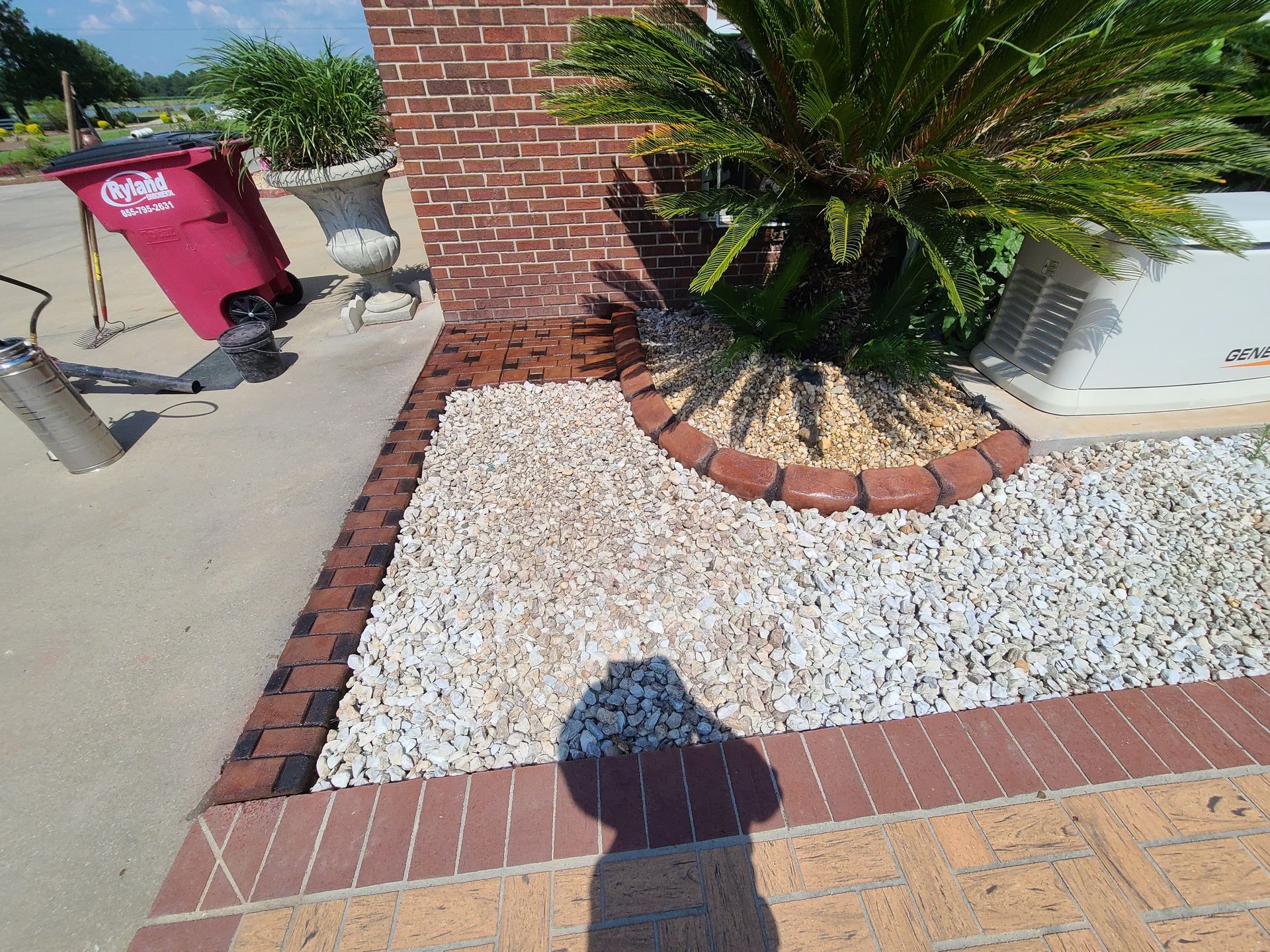 A brick building with a red trash can in front of it