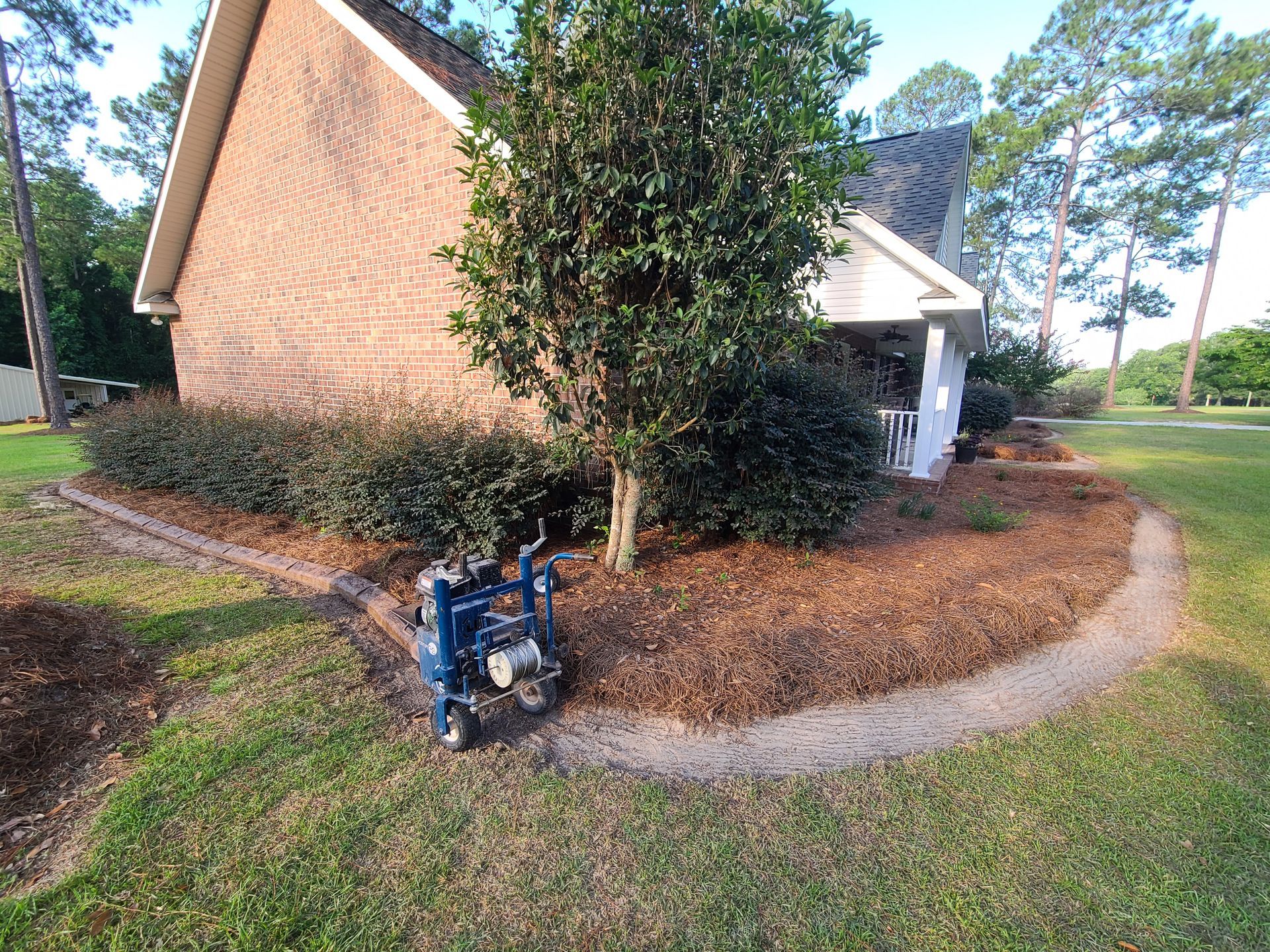 A blue wheelchair is parked in front of a brick house.