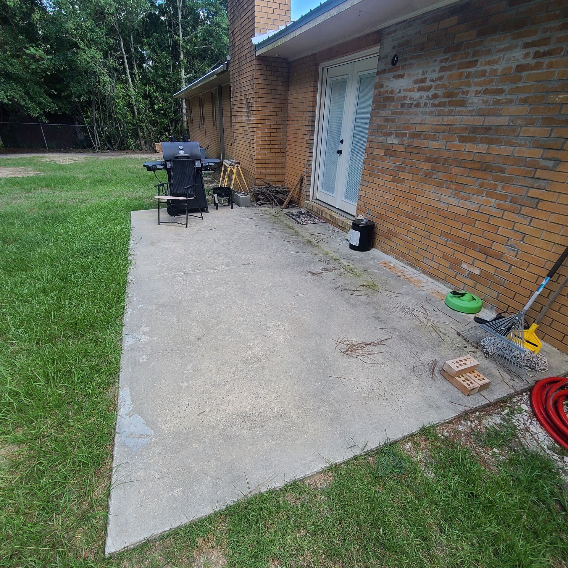 A brick house with a concrete patio in front of it.