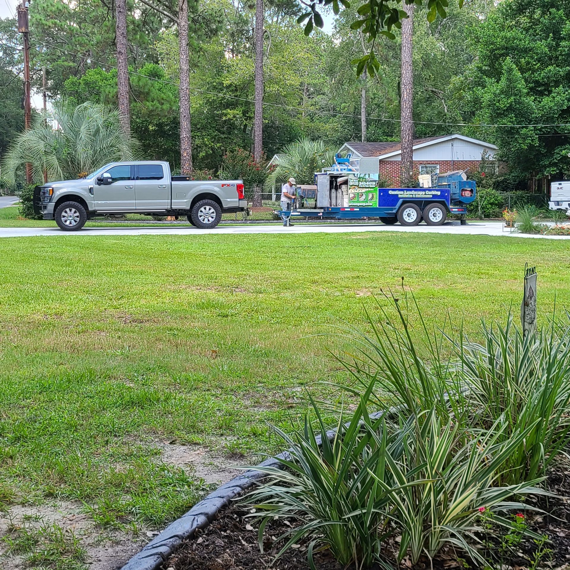 A truck and trailer are parked on the side of the road.