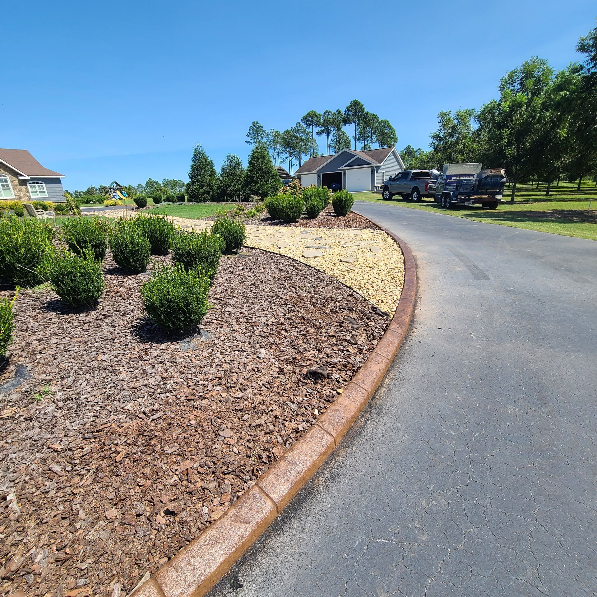 A truck is parked on the side of the road in front of a house.