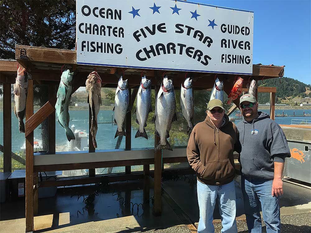 Two Men Standing in Front of A Sign