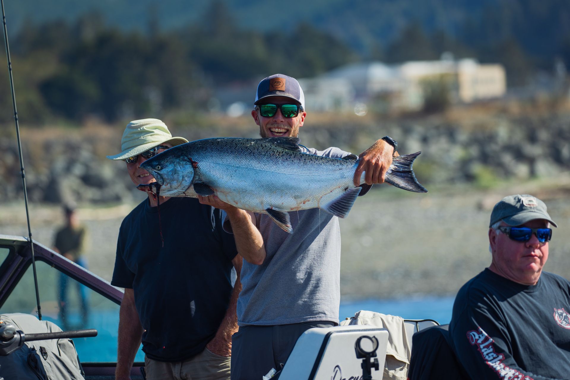 Man is Holding a Large Fish While Standing on A Boat