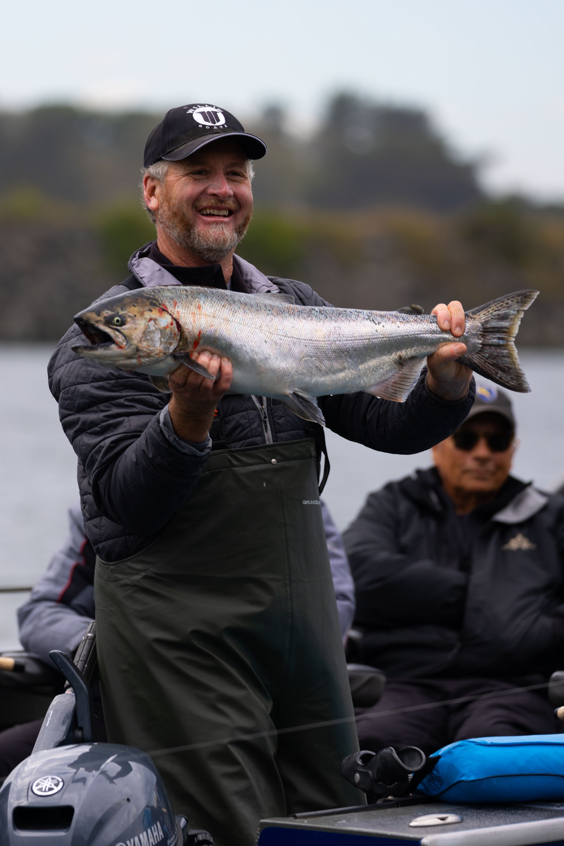 Man Is Holding a Large Fish in His Hands While Standing on A Boat