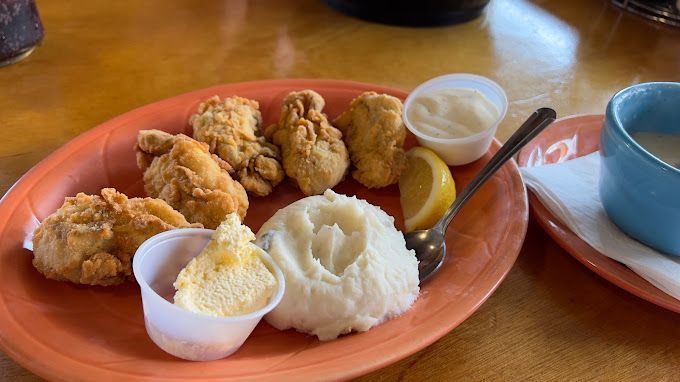 A Plate of Food with Mashed Potatoes and Fried Chicken on A Table