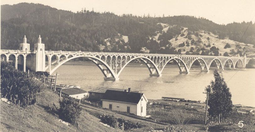 A Black and White Photo of A Bridge Over a Body of Water