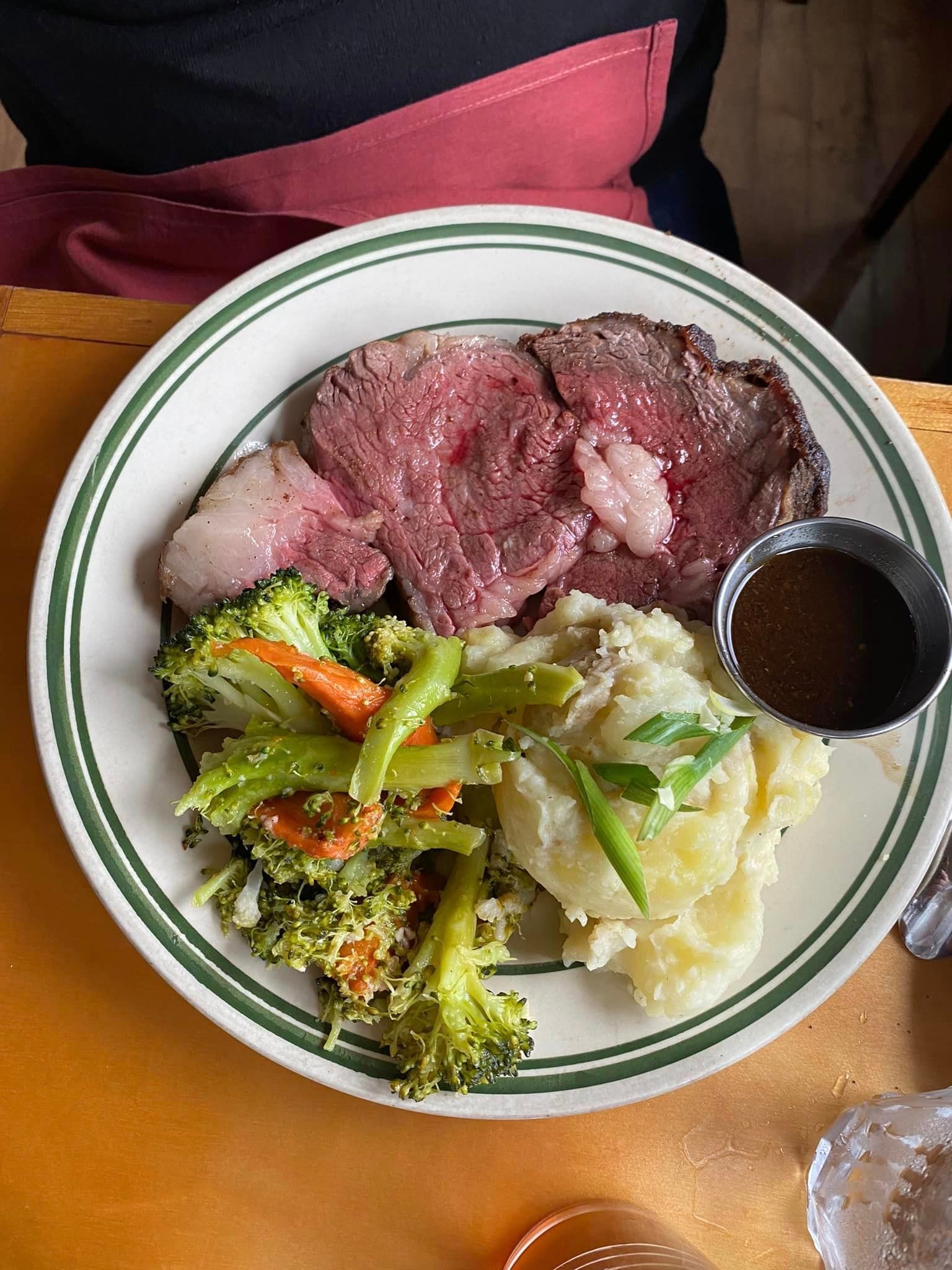 Plate of Food with Meat , Broccoli , Mashed Potatoes and Gravy on A Table