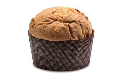 Un panettone cotto al forno, a forma di cupola, in uno stampo di carta marrone decorata, su sfondo bianco.