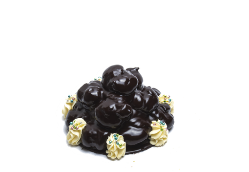 Una torta profiterole al cioccolato con strati di bignè di pasta sfoglia glassati al cioccolato fondente e guarniti con ciuffi di panna montata.