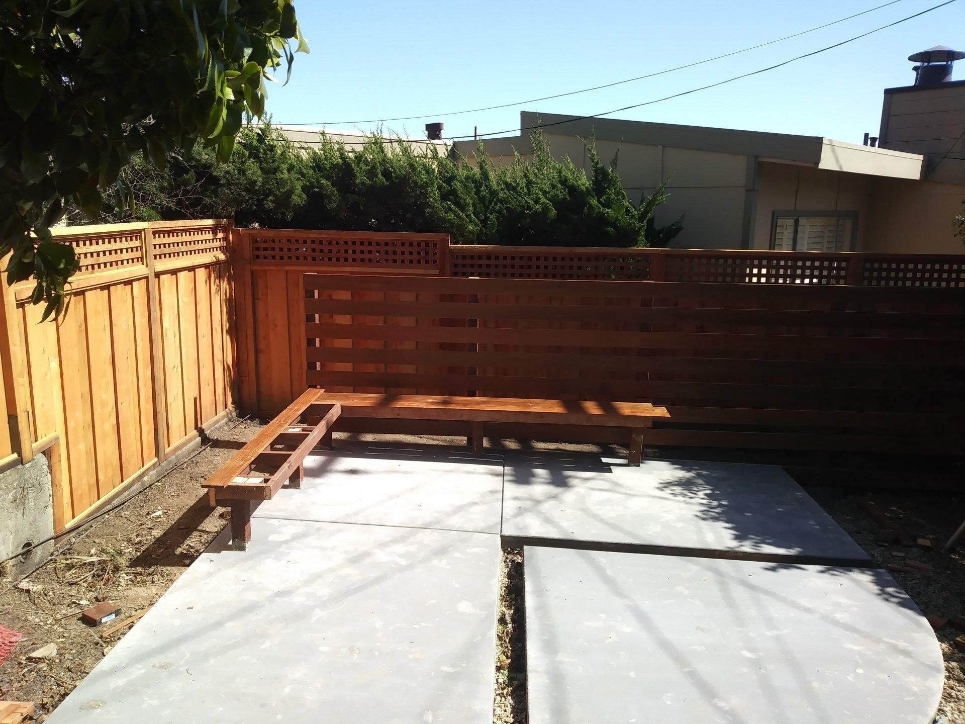 A backyard with a wooden fence and a bench