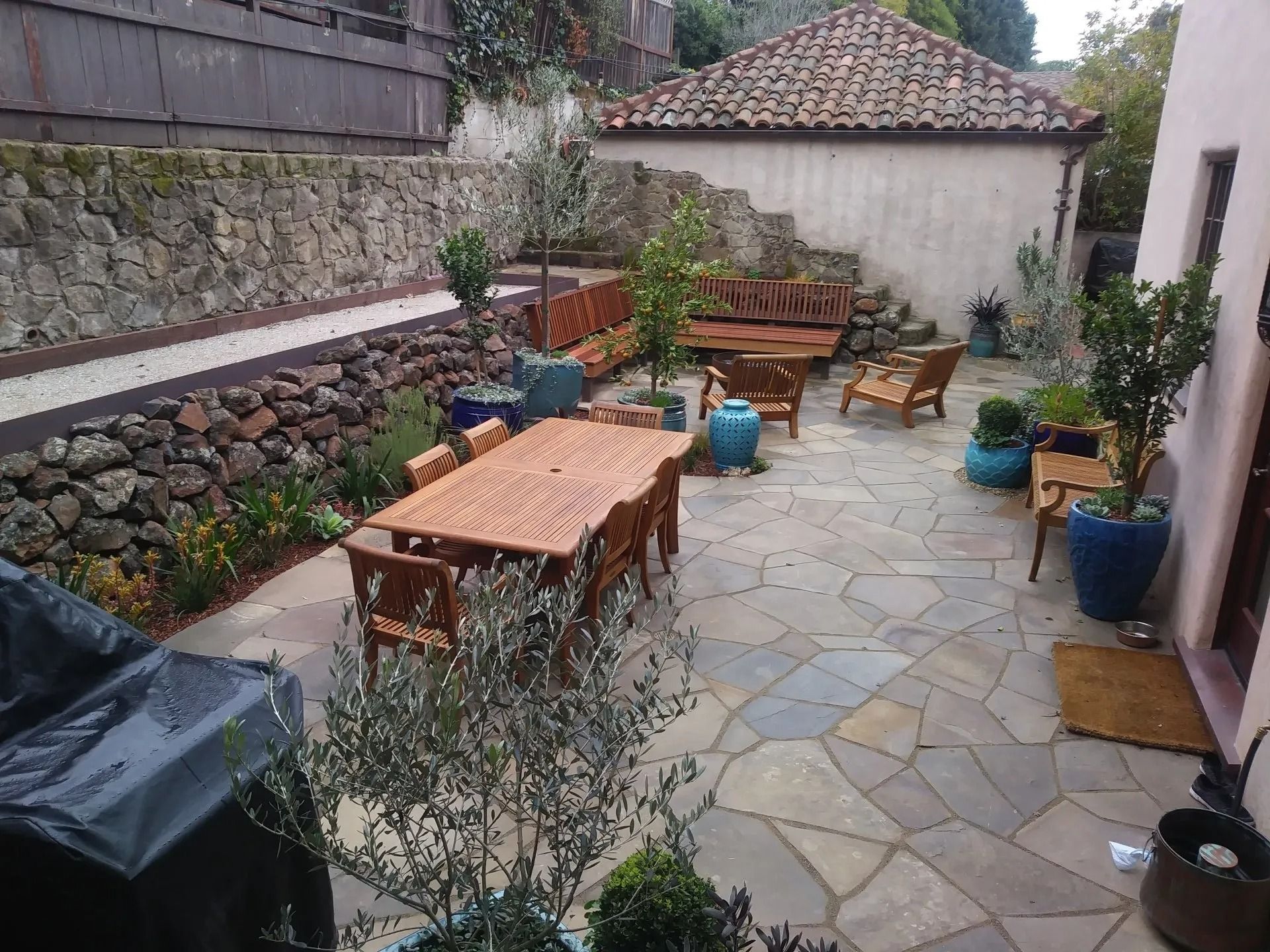 A patio with a table and chairs and a grill