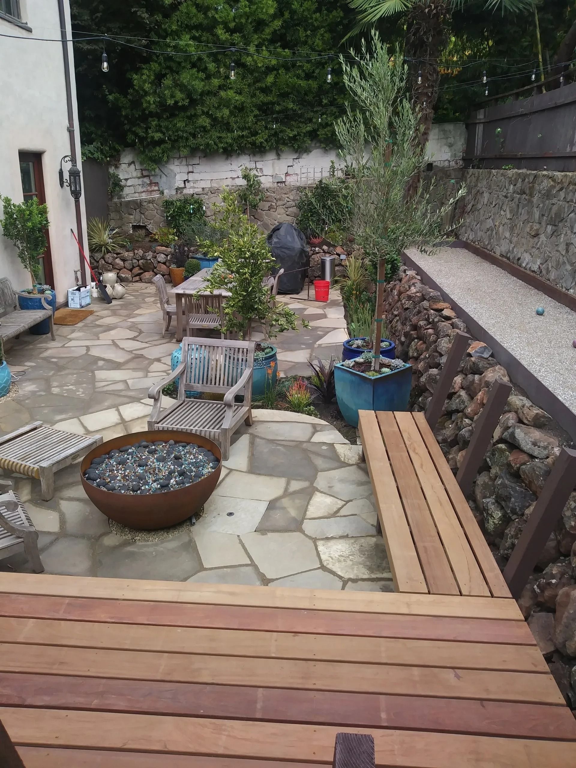 There is a wooden deck in the middle of the garden.