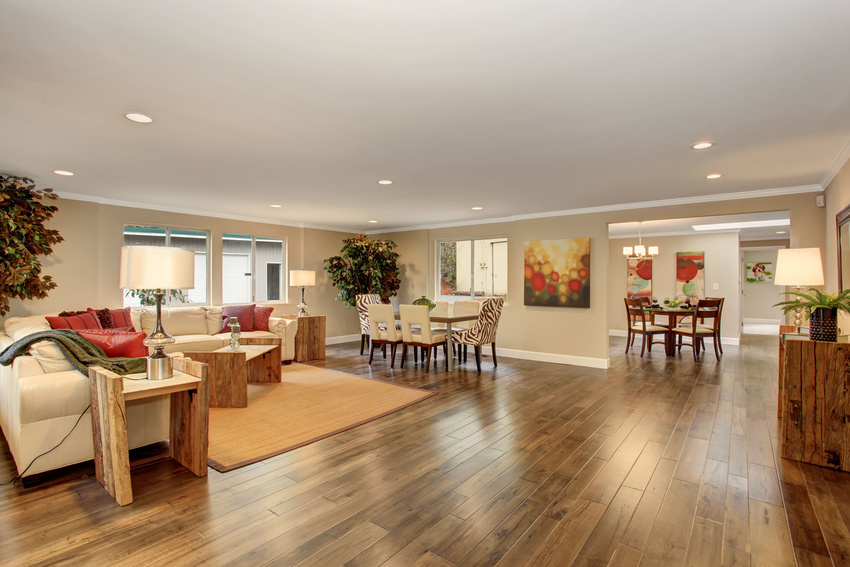 Spacious living and dining area with wood floors, beige walls, and modern furniture in warm neutral tones