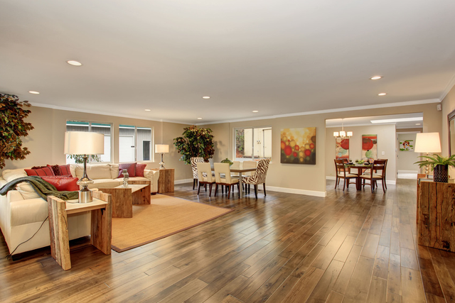 Spacious living and dining area with wood floors, beige walls, and modern furniture in warm neutral tones