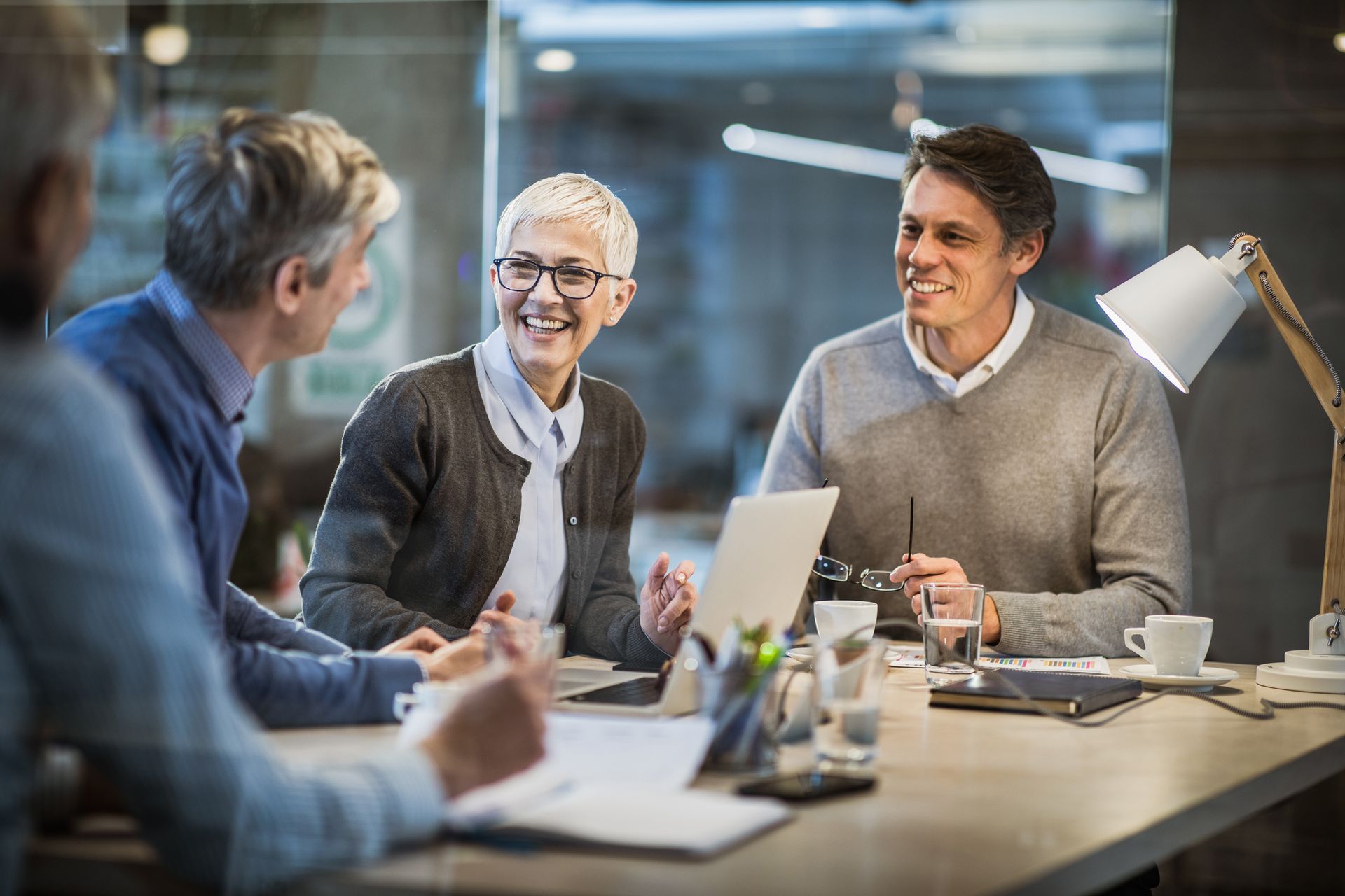 A group of people are sitting around a table having a meeting.