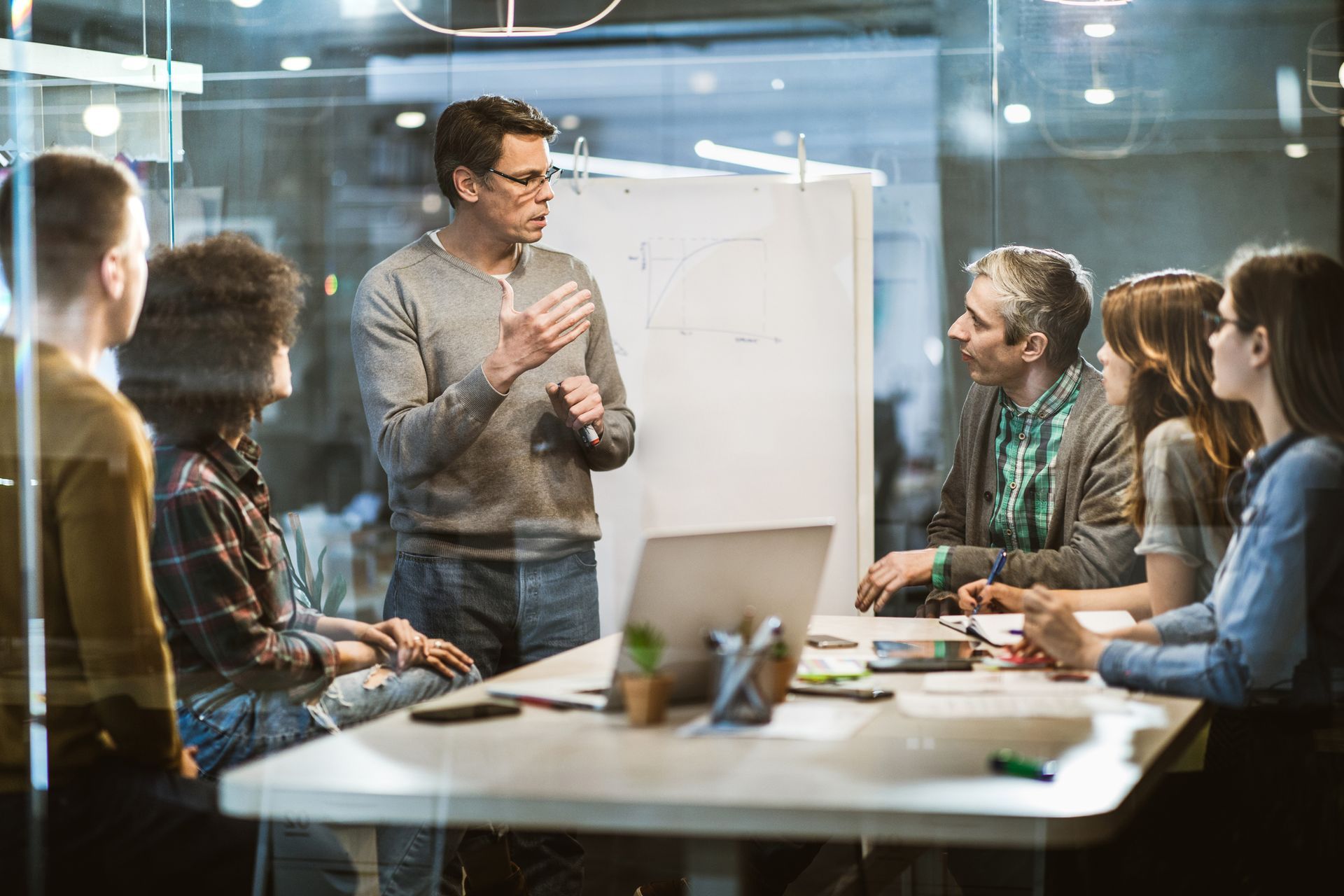 A man is giving a presentation to a group of people in a conference room.